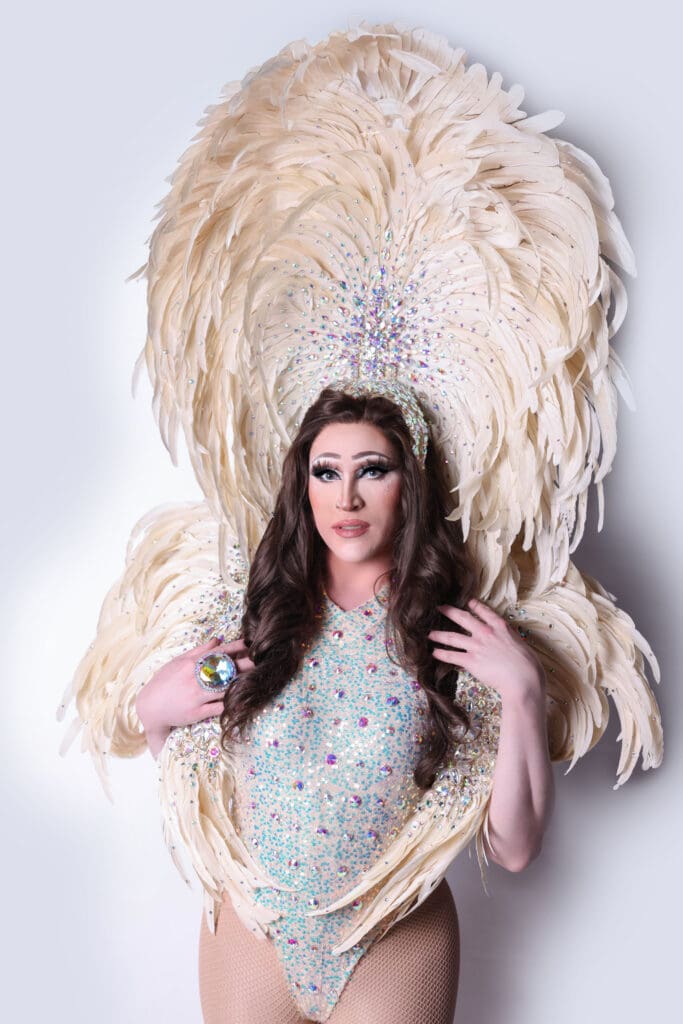 Drag queen in feather headdress and bodysuit.