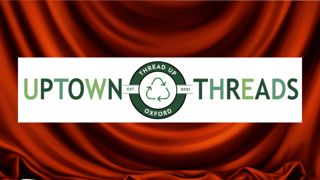 Uptown Threads logo in front of a red silk curtain