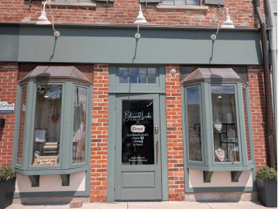 Exterior of Blessed Links Jewelry with red brick and green window panels.