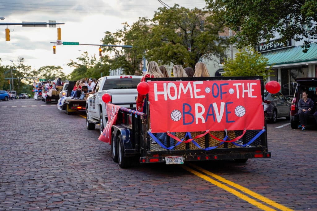 Parade truck with sign that says "Home of the Brave"