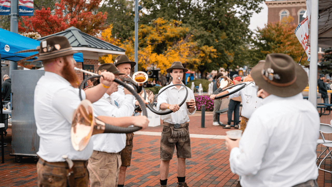 German hunting horn performers playing together in Uptown Oxford, OH