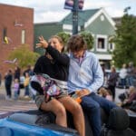 Two members of the Talawanda HS Homecoming Court ride on the back of a convertible in the parade.