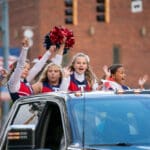 A group of cheerleaders rides on the back of a truck during the Talawanda HS Homecoming parade.