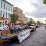 A group of students rides on a trailer being pulled by a truck in the Talawanda HS Homecoming parade.