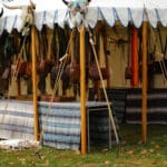 Pioneer-style leather bags hang from the ceiling of a vendor's tent.