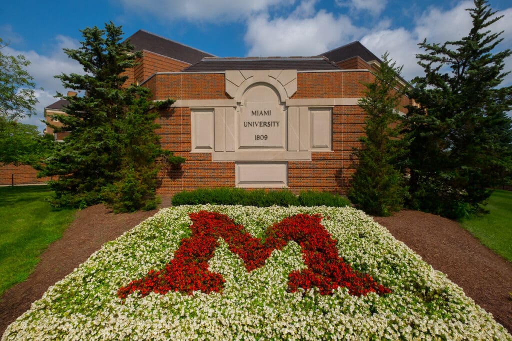 Miami University Signage that reads "Miami University 1809" with a giant "M" in the floral landscaping in front of the sign.