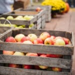 Wooden crates filled with apples sit on top of a table.