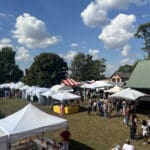Aerial view of the Apple Butter Festival showing event attendees exploring rows of vendor tents.