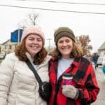 Two women stand in the middle of Uptown Oxford, posing for the camera.