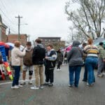 Groups of people congregate in the streets of Uptown Oxford, as vendor booths line the streets on either side.