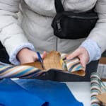 A person wrapping gifts at a table.