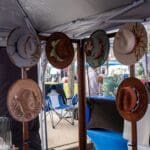 Various decorative hats are prominently displayed at a vendor booth.