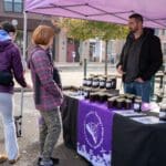 A local vendor sells jars of preserves from their booth.