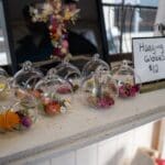 Various hanging globes sit atop a table, available for sale.