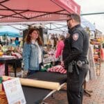 A police officer speaks with a worker at the information booth.