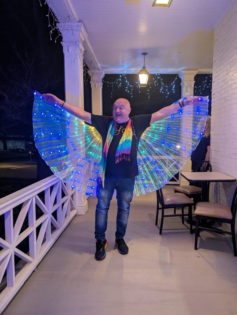 Oxford Pride Prom guest posing with iridescent wings.