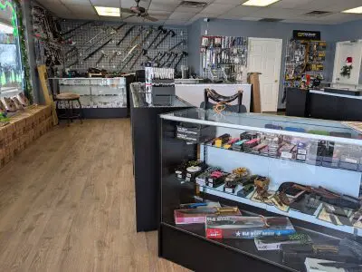 Glass cases filled with various types of knives and a wall of axes, swords, and more.