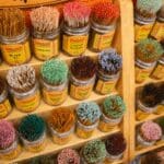 a shelf with rows of rainbow colored incense sticks