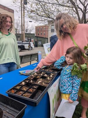 A n adult and child exploring a Earth Fest booth together