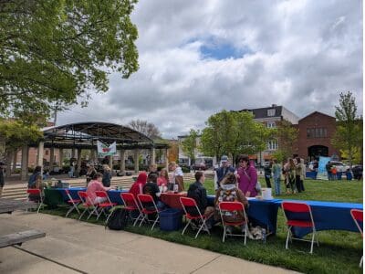 Row of Earth Fest booths along the sidewalk of Oxford Memorial Park.