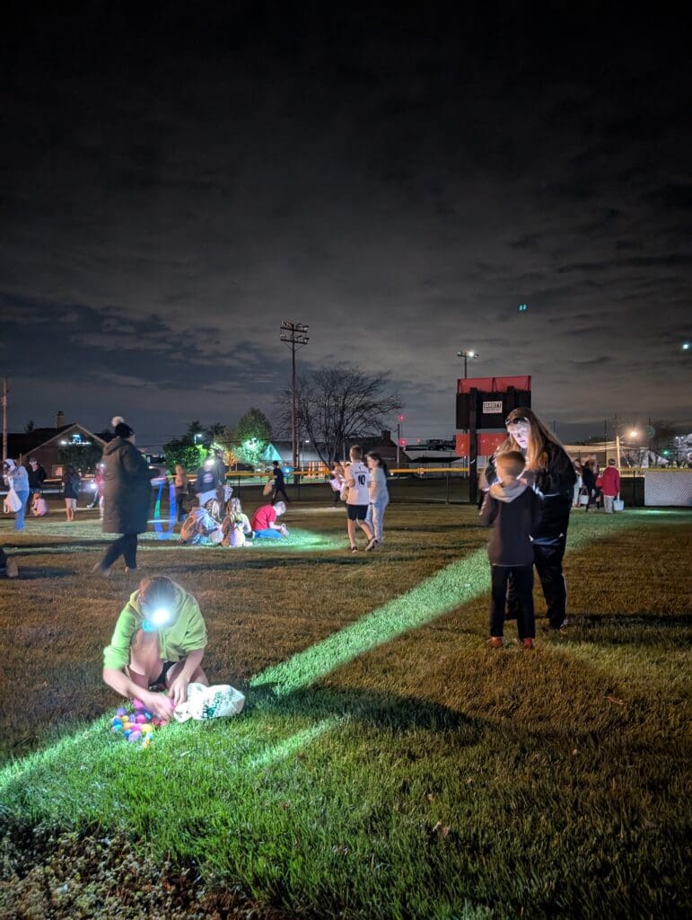 kids with headlamps looking through their eggs