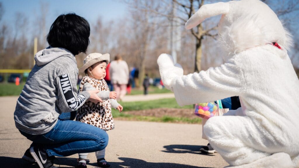 White bunny high fives a toddler