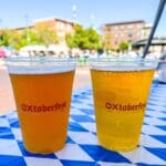 A couple of beers in plastic cups with "OXtoberfest" on them.