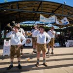 German musicians playing horns on the outdoor stage.