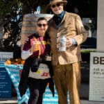A man and woman pose for the camera holding beer steins.