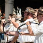 Three musicians playing German hunting horns