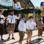 Musicians dressed in traditional German garb hanging out on the main stage