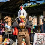 A man dressed in a chicken costume stands on the main stage.