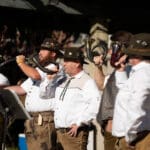 A group of musicians dressed in traditional German attire plays their instruments on the main stage.