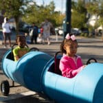 Kids riding in a rain barrel train.