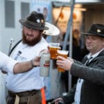 Four musicians dressed in German garb cheers their beers.