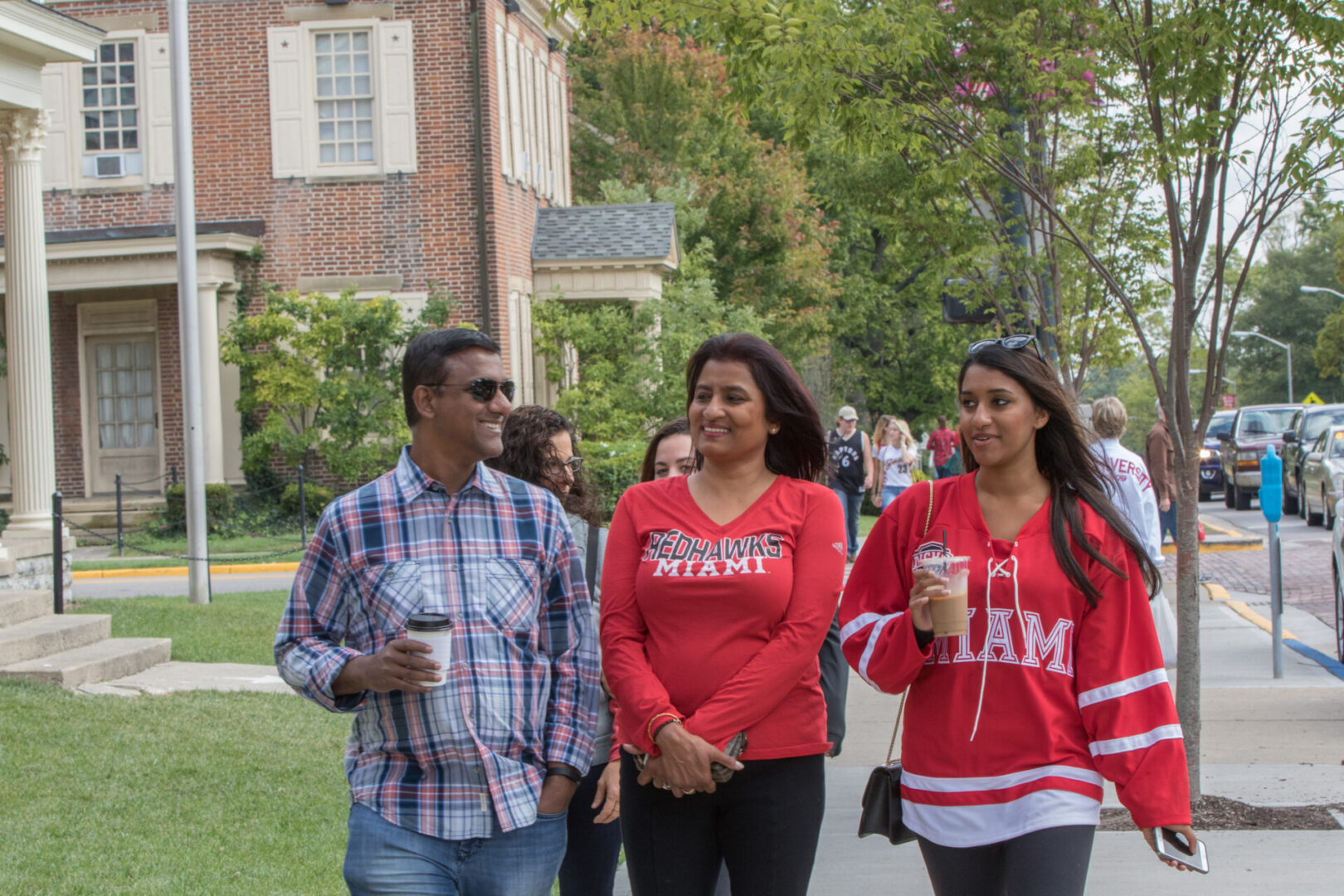 A Miami University student walks down the sidewalk with her parents as they explore Miami University's campus.