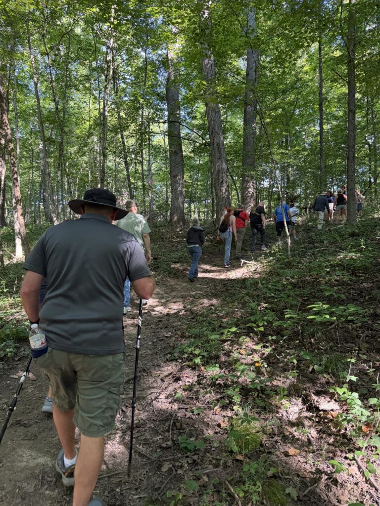 A group of people hikes up a hill on the Big Woods Trail at Hueston Woods.
