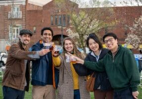 group of five people toasting with DORA beverages
