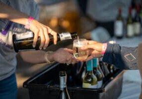 a close up of wine pouring into a tasting glass