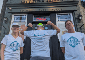 Group posing of three in front of Left Field Tavern in Pub Run T-shirts