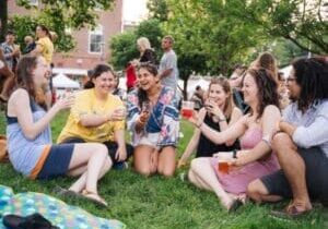 A group of people sitting on the lawn at the park drinking wine and craft beer at MLK Jr. Park
