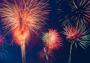 A group of fireworks are lit up in the night sky.